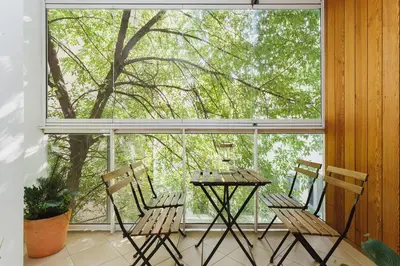 a table and chairs in front of a large window at 3-Bedroom Apartment with balcony- Krowoderska in Kraków