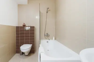 a bathroom with a tub and a toilet and a sink at 3-Bedroom Apartment with balcony- Krowoderska in Kraków