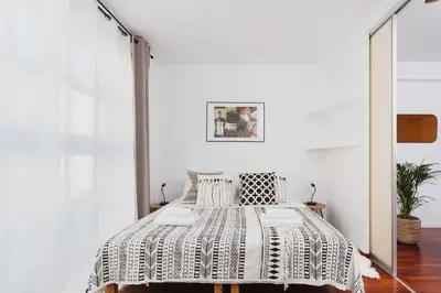 a bedroom with a bed with a black and white comforter at 3-Bedroom Apartment with balcony- Krowoderska in Kraków