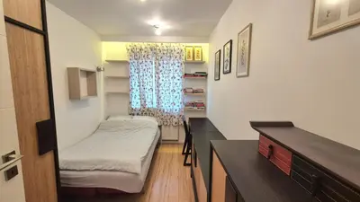 a small room with a bed and a desk at Apartament Zielony Z Ogrodem in Kraków