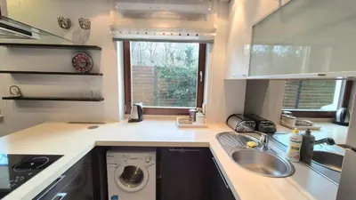 a kitchen with a sink and a washing machine at Apartament Zielony Z Ogrodem in Kraków