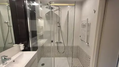 a glass shower in a bathroom with a sink at Apartament Zielony Z Ogrodem in Kraków