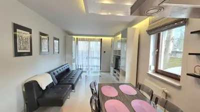 a living room with a table and a couch at Apartament Zielony Z Ogrodem in Kraków