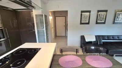 a kitchen with a stove and a table with chairs at Apartament Zielony Z Ogrodem in Kraków