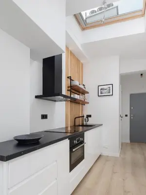 a kitchen with white cabinets and a black counter top at Apartment in Kazimierz District - Starowislna 43 in Kraków