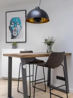a dining table with a black lamp and a desk with chairs at Apartment in Kazimierz District - Starowislna 43 in Kraków