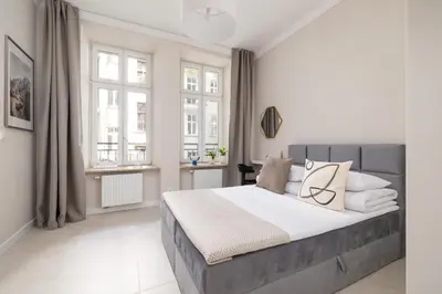 a white bedroom with a large bed and windows at Studio for two - Kazimierz- 43 Starowiślna Street in Kraków