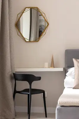 a black chair and a mirror in a bedroom at Studio for two - Kazimierz- 43 Starowiślna Street in Kraków