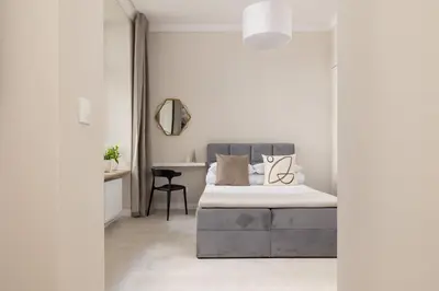 a white bedroom with a bed and a desk at Studio for two - Kazimierz- 43 Starowiślna Street in Kraków