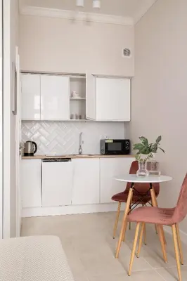 a kitchen with white cabinets and a table and chairs at Studio for two - Kazimierz- 43 Starowiślna Street in Kraków