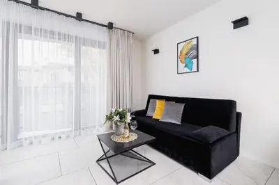a living room with a black couch and a table at Modern Apartment Old Town Cracow by Noclegi Renters in Kraków