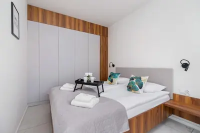 two beds in a room with a table at Modern Apartment Old Town Cracow by Noclegi Renters in Kraków
