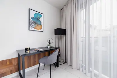 a desk and a chair in a room with a window at Modern Apartment Old Town Cracow by Noclegi Renters in Kraków