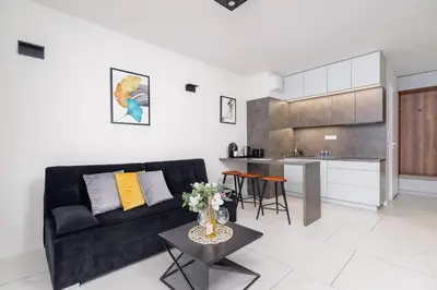 a living room with a black couch and a table at Modern Apartment Old Town Cracow by Noclegi Renters in Kraków