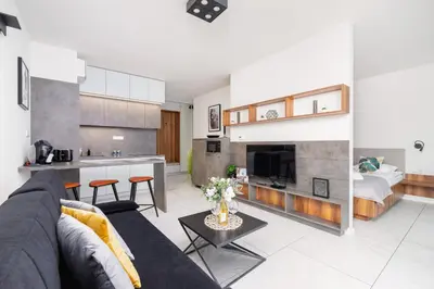 a living room with a couch and a kitchen at Modern Apartment Old Town Cracow by Noclegi Renters in Kraków