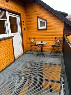 a patio with a table and chairs on a house at Gnapówka in Zawoja