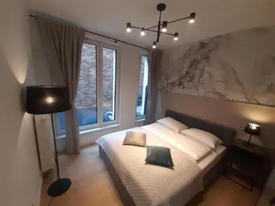 a bedroom with a bed and a large window at Apollo Apartments Prochowa 6 in Kraków