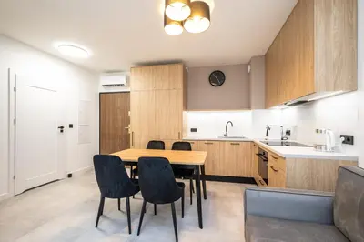 a kitchen with a wooden table and chairs at Apollo Apartments Prochowa 6 in Kraków