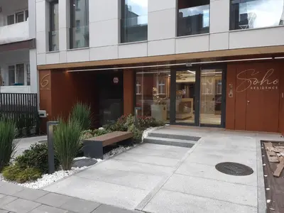 a building with a bench in front of it at Apollo Apartments Prochowa 6 in Kraków