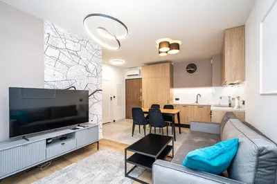 a living room with a large television and a table at Apollo Apartments Prochowa 6 in Kraków