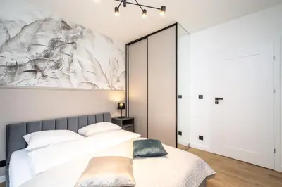 a bedroom with a bed and a painting on the wall at Apollo Apartments Prochowa 6 in Kraków