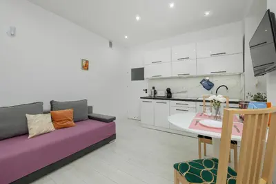 a living room with a purple couch and a table at Central Kraków Apartment by Noclegi Renters in Kraków