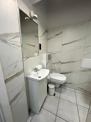 a white bathroom with a toilet and a sink at Central Kraków Apartment by Noclegi Renters in Kraków
