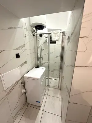a small bathroom with a toilet and a shower at Central Kraków Apartment by Noclegi Renters in Kraków