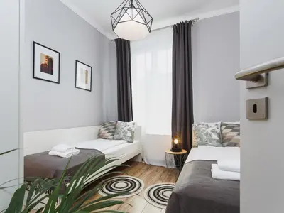 a living room with two beds and a window at Two Bedroom Apartment - Rzeszowska 4 in Kraków