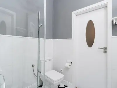 a white bathroom with a toilet and a shower at Two Bedroom Apartment - Rzeszowska 4 in Kraków