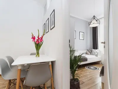 a white dining room with a table and chairs at Two Bedroom Apartment - Rzeszowska 4 in Kraków