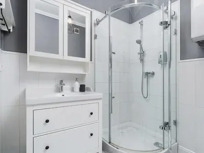 a white bathroom with a shower and a sink at Two Bedroom Apartment - Rzeszowska 4 in Kraków