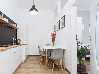 a kitchen and dining room with a table and chairs at Two Bedroom Apartment - Rzeszowska 4 in Kraków