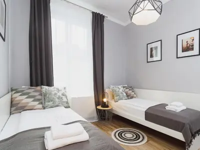 a bedroom with two beds and a window at Two Bedroom Apartment - Rzeszowska 4 in Kraków