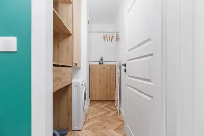 a bathroom with a washer and dryer and a door at Podgórze Golden Oriole Apartment Cracow by Renters Prestige in Kraków