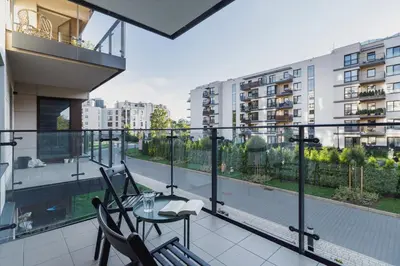 a balcony with a table and chairs on a balcony at Podgórze Golden Oriole Apartment Cracow by Renters Prestige in Kraków
