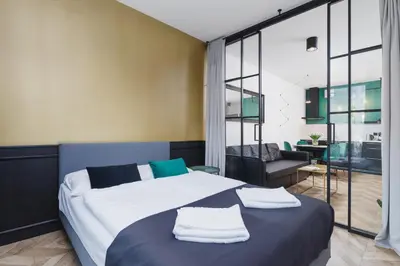 a bedroom with a large bed with towels on it at Podgórze Golden Oriole Apartment Cracow by Renters Prestige in Kraków