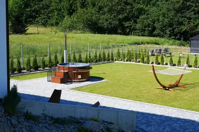 a garden with a hot tub and a hammock at House for 20 people with a private SPA and bar Koma House in Sidzina