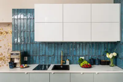a kitchen with white cabinets and fruit on a counter at Rooftop Wawel view with jacuzzi l luxury apartment in Kraków