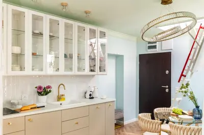 a kitchen with white cabinets and a glass table at Rooftop Wawel view with jacuzzi l luxury apartment in Kraków