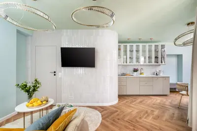 a kitchen and living room with a tv on a wall at Rooftop Wawel view with jacuzzi l luxury apartment in Kraków