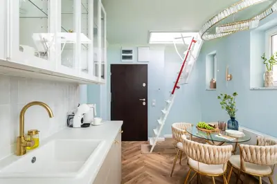 a kitchen with a sink and a table with chairs at Rooftop Wawel view with jacuzzi l luxury apartment in Kraków