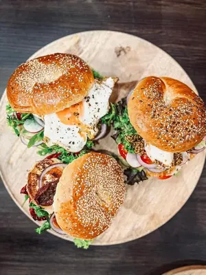 three sandwiches on a plate on a table at Rooftop Wawel view with jacuzzi l luxury apartment in Kraków