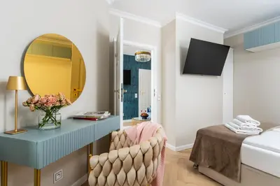 a bedroom with a blue desk with a mirror and a bed at Rooftop Wawel view with jacuzzi l luxury apartment in Kraków