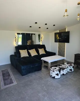 a living room with a black couch and a table at TinyApartament in Skawa
