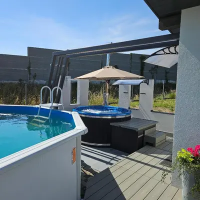 a patio with a swimming pool and an umbrella at TinyApartament in Skawa