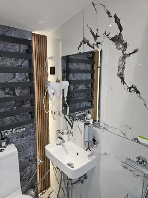 a white bathroom with a sink and a mirror at TinyApartament in Skawa