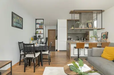a living room and kitchen with a table and chairs at Zbożowa 2A Apartments Nowy Kleparz Cracow by Noclegi Renters in Kraków