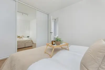 a white bedroom with a bed and a table at Zbożowa 2A Apartments Nowy Kleparz Cracow by Noclegi Renters in Kraków