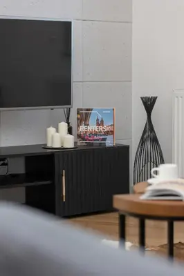 a living room with a tv and a table at Zbożowa 2A Apartments Nowy Kleparz Cracow by Noclegi Renters in Kraków